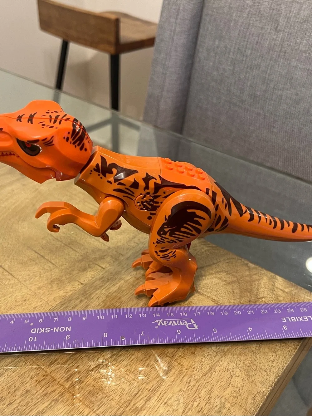 orange-and-brown molded plastic Tyrannosaurus Rex dinosaur makes noise building